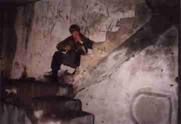 Unkas sedící a kouřící na schodech těžkého bunkru